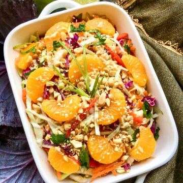 Asian cabbage salad with peanut dressing in a white dish