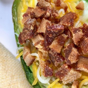 Avocados cut in half and baked with eggs, cheese, and bacon.