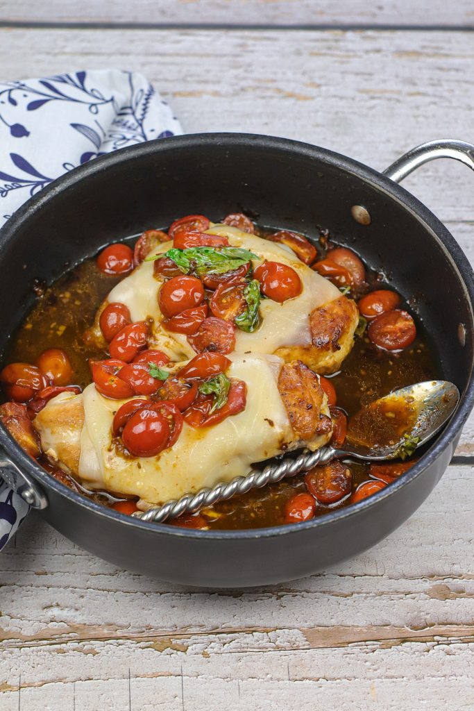 caprese chicken in a pan of sauce 