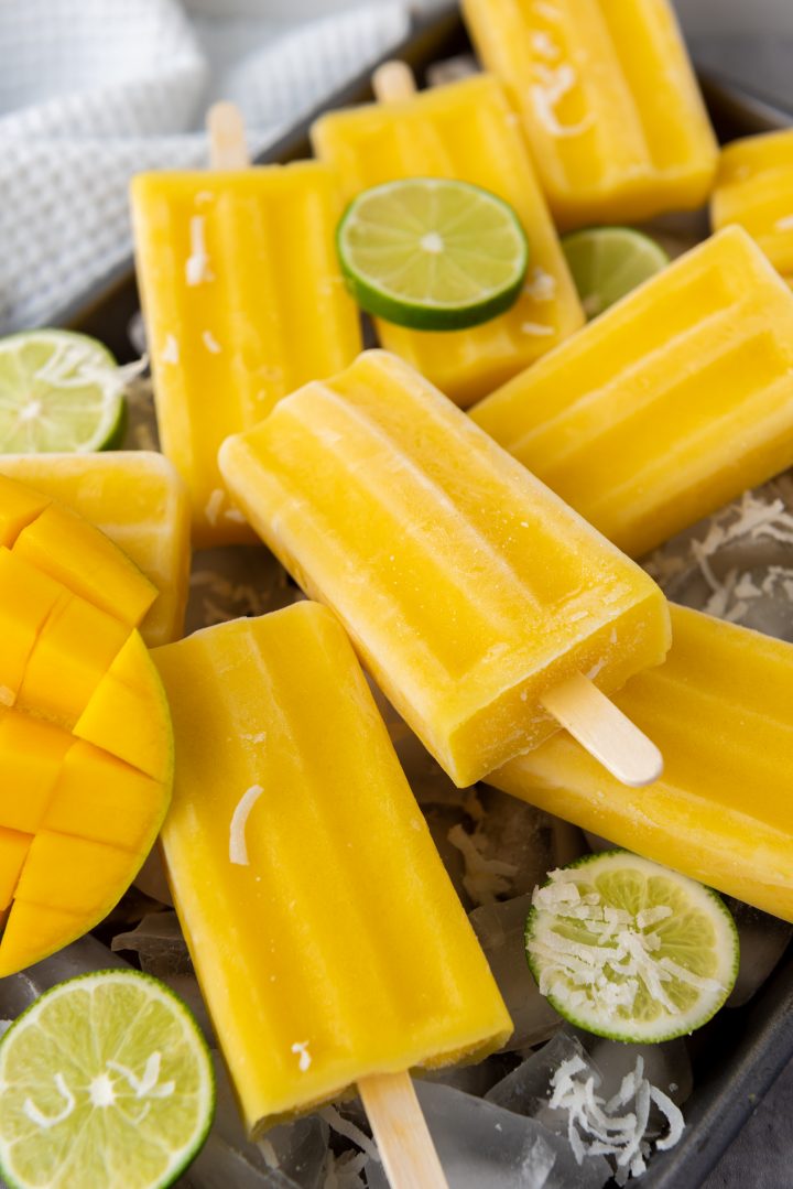 mango popsicles laying with other lime popsicles