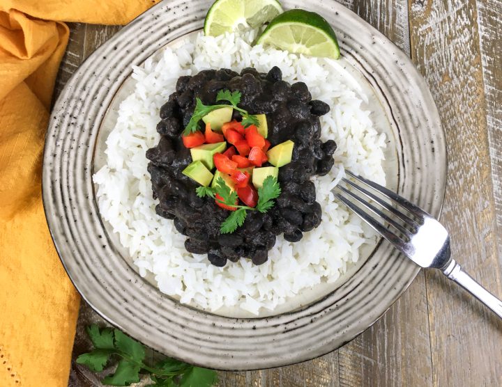 homemade black beans on a white plate with rice