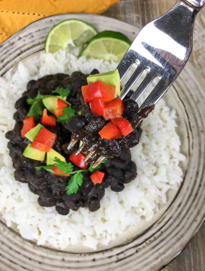 homemade black beans on a white plate with rice