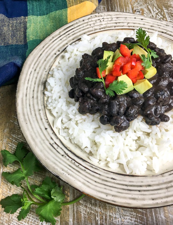 homemade black beans on a white plate with rice