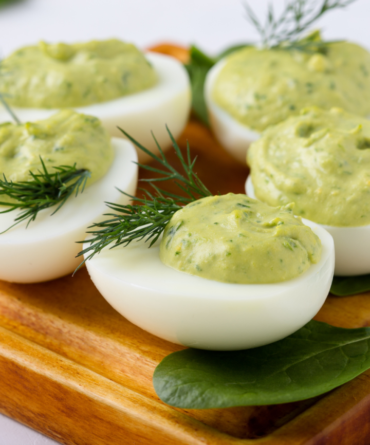 avocado deviled eggs on a brown board