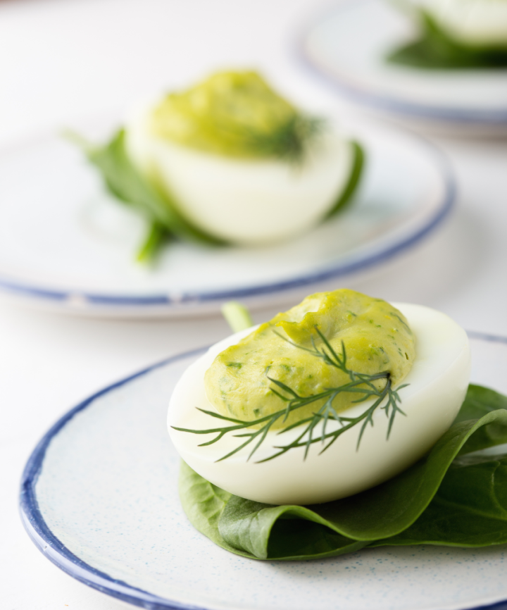 avocado deviled eggs on a brown board