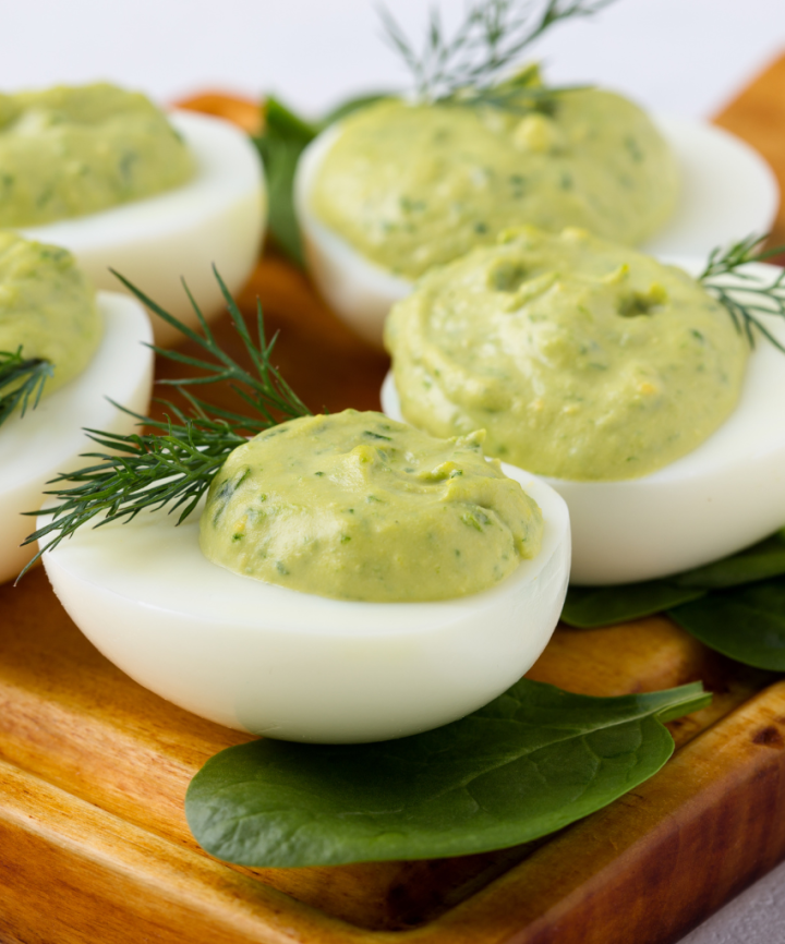 avocado deviled eggs on a brown board