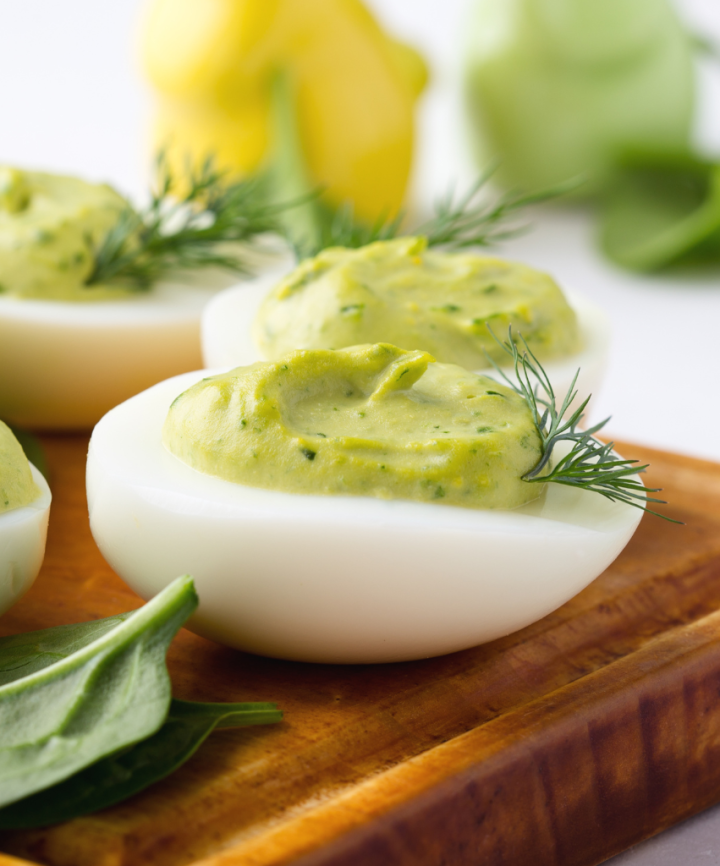 avocado deviled eggs on a brown board