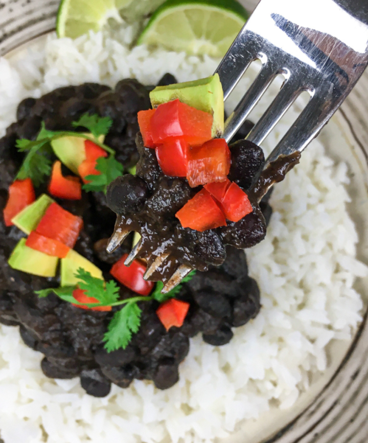 homemade black beans on a white plate with rice