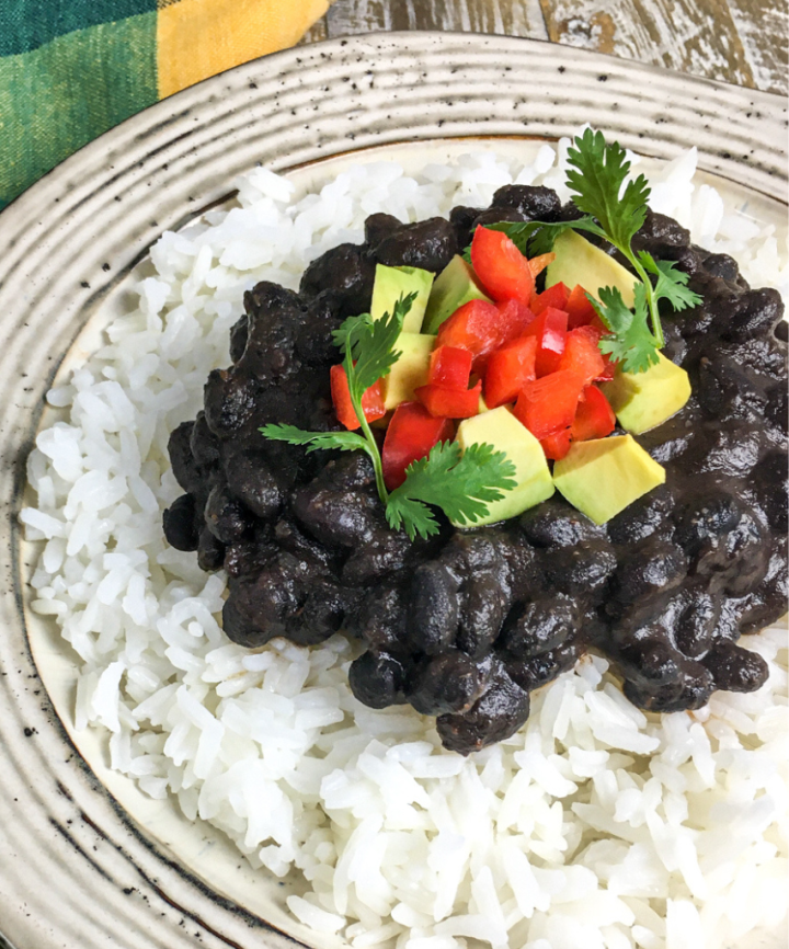 homemade black beans on a white plate with rice