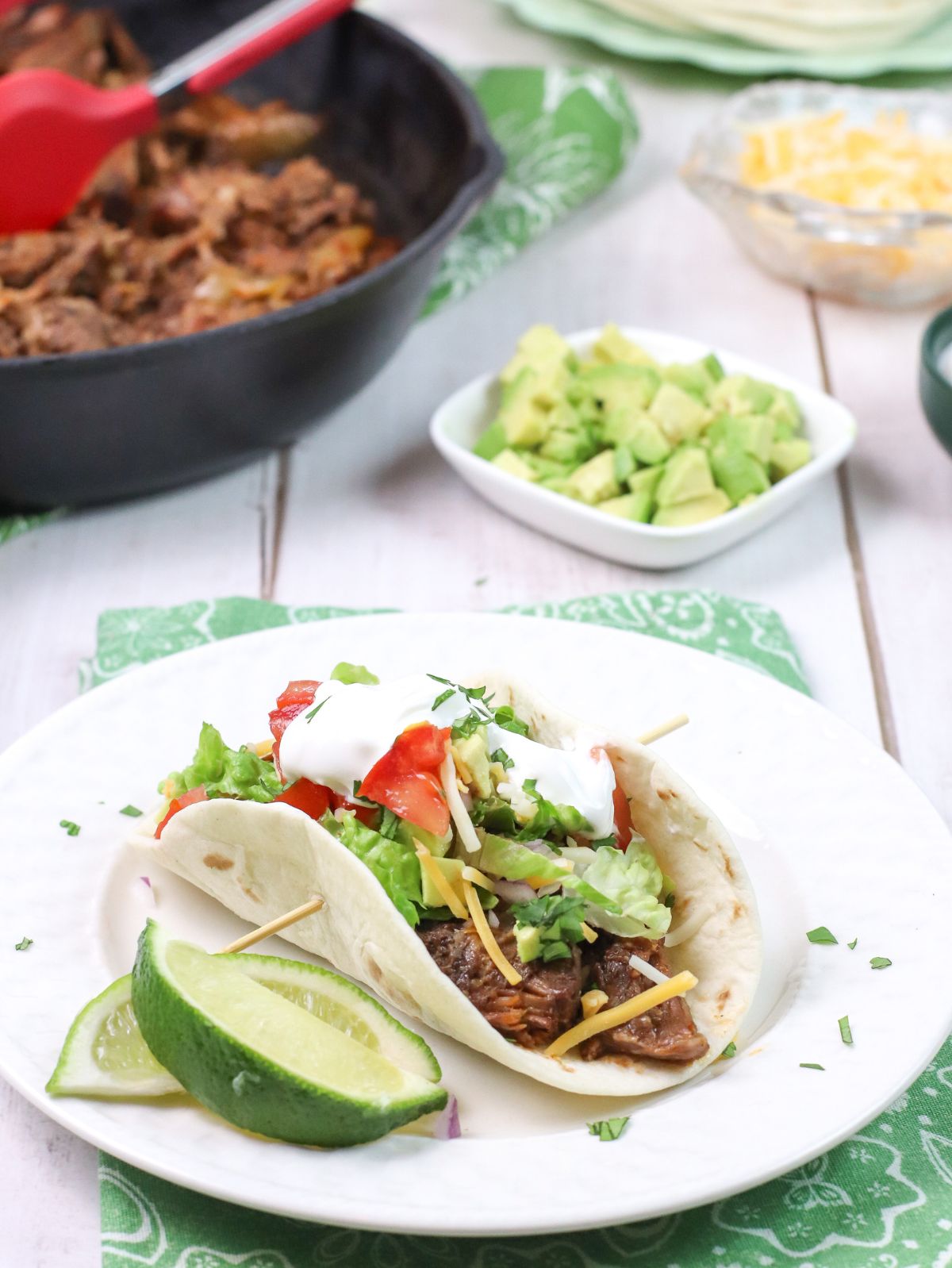 a taco on a white plate with a lime