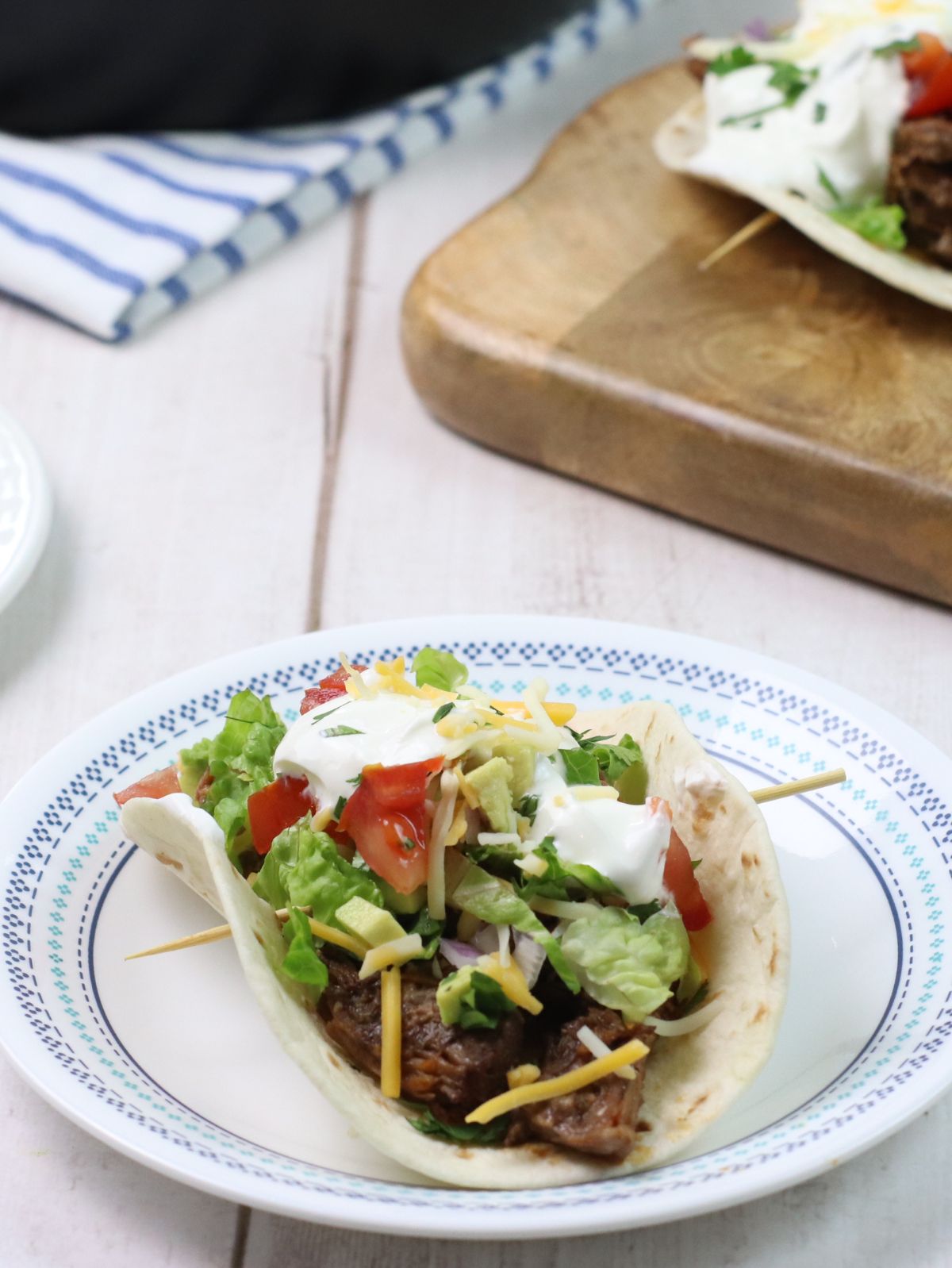 barbacoa taco on a white and blue plate