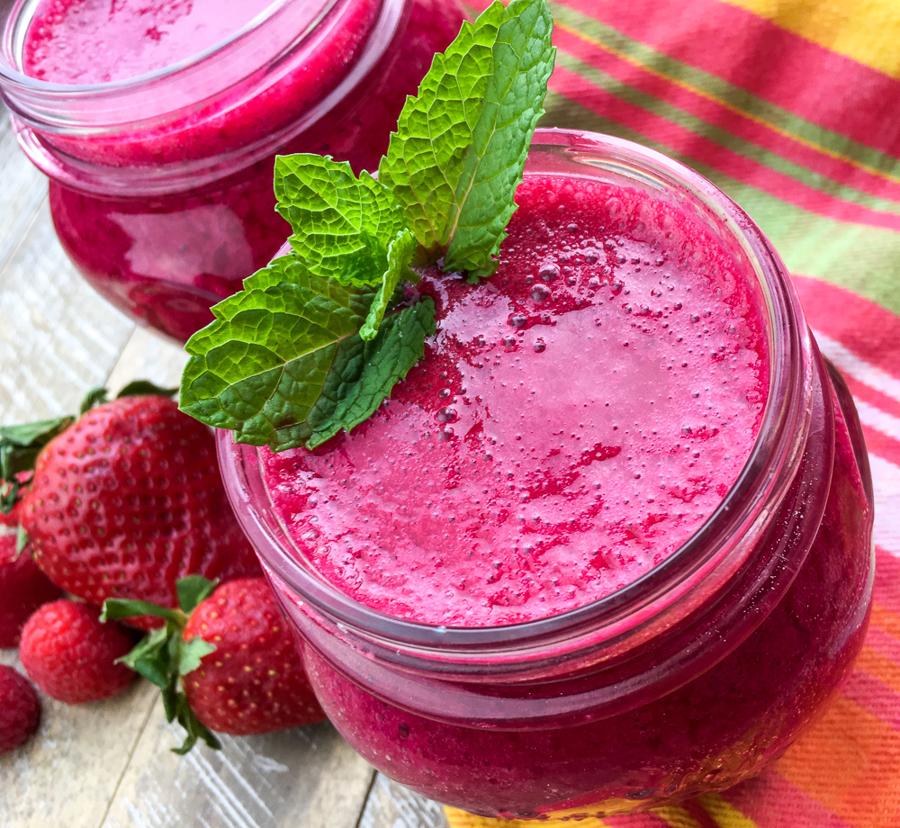 Beet and berries smoothie on a colorful table cloth.