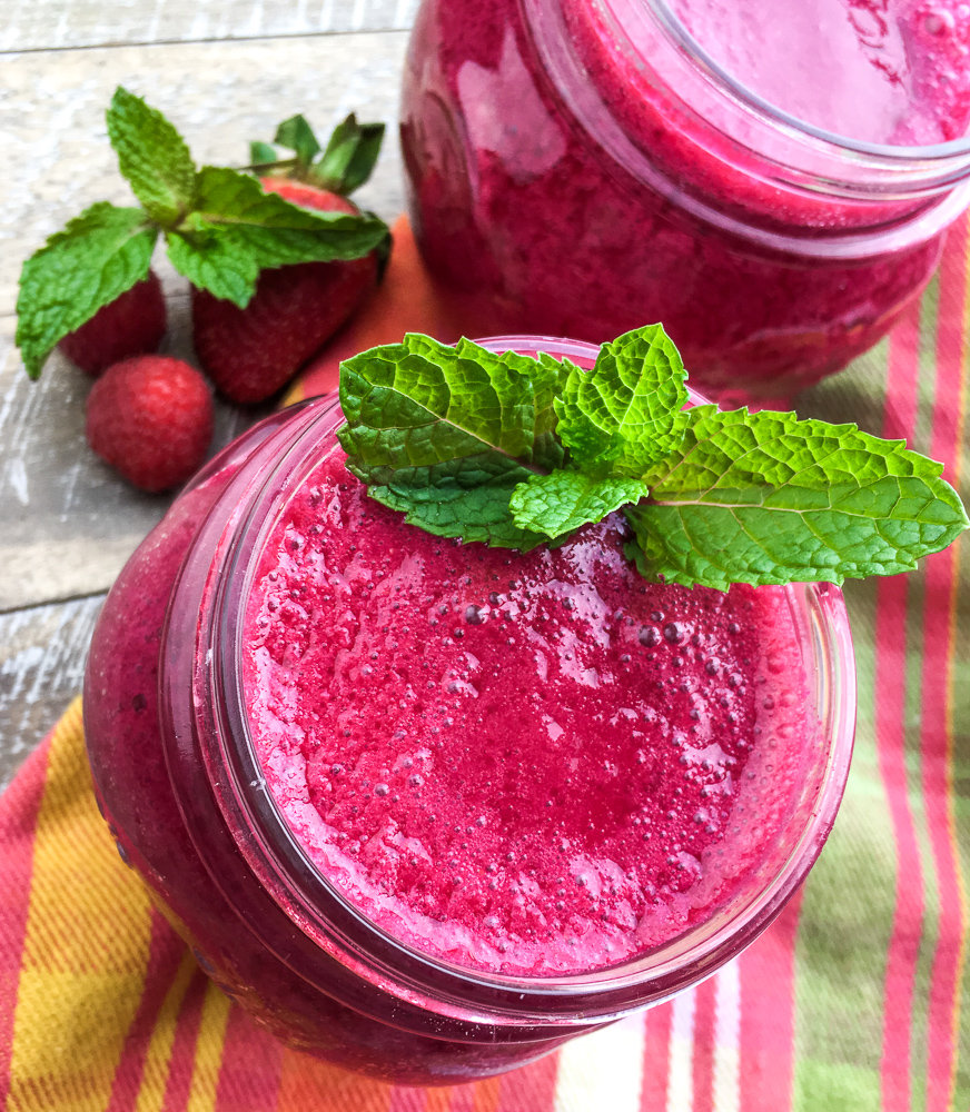 Beet and berries smoothie on a colorful table cloth.