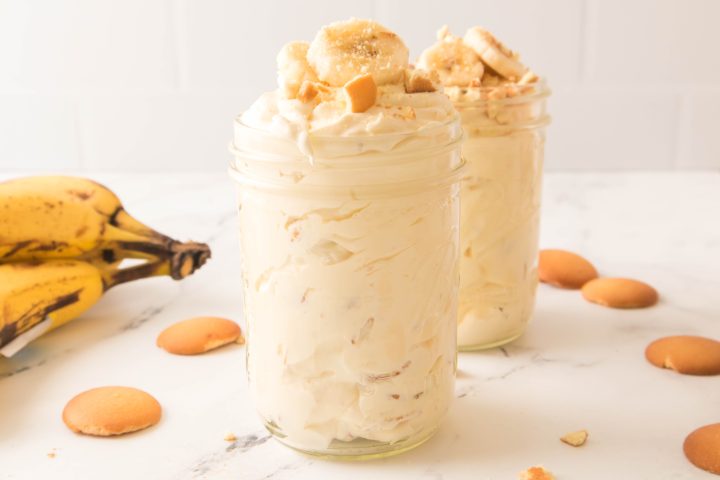 Banana pudding in a jar with banana slices and crushed vanilla wafers on top