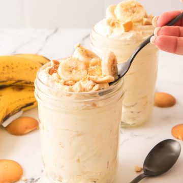 Banana pudding in a jar with a spoon in it