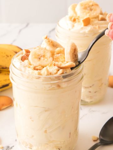 Banana pudding in a jar with a spoon in it