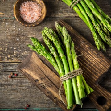 banches of fresh green asparagus on wooden background