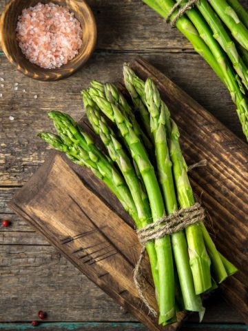 banches of fresh green asparagus on wooden background