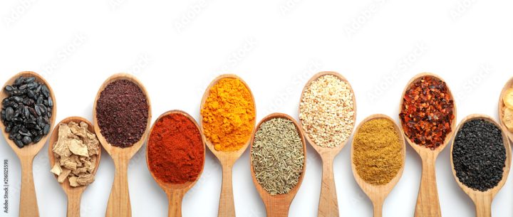 Composition with different aromatic spices in wooden spoons on white background