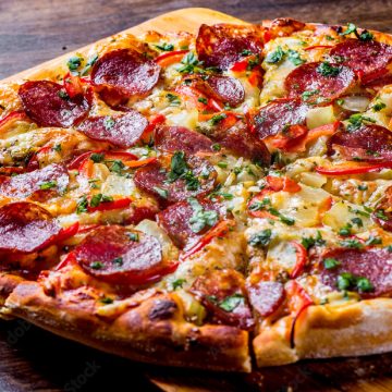 Pepperoni Pizza with Mozzarella cheese, salami, pepper. Spices and Fresh basil. Italian pizza on wooden table background