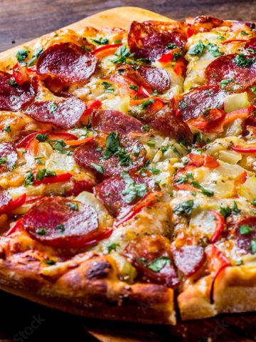 Pepperoni Pizza with Mozzarella cheese, salami, pepper. Spices and Fresh basil. Italian pizza on wooden table background