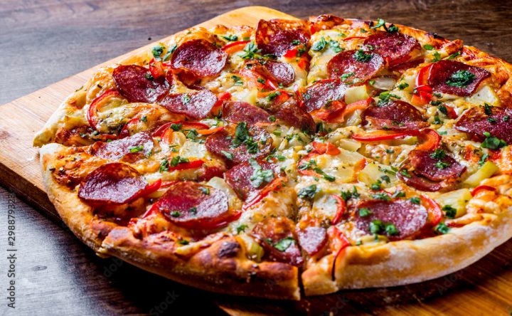 Pepperoni Pizza with Mozzarella cheese, salami, pepper. Spices and Fresh basil. Italian pizza on wooden table background